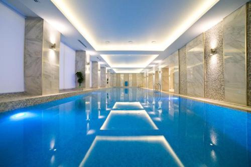 a swimming pool with blue water in a building at ART Hotel in Kirov