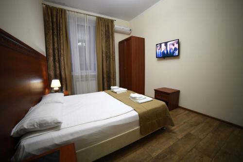 クラスノダールにあるHotel Kruizのベッドとテレビ付きのホテルルーム