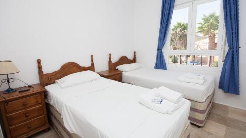 マニルバにあるVillas del Golf 23のベッドルーム1室(ベッド2台、窓付)