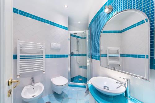 uma casa de banho azul e branca com um lavatório e um WC em casa la perla em Minori