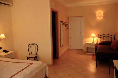 a bedroom with a bed and a chair in a room at Hotel Relais Modica in Modica