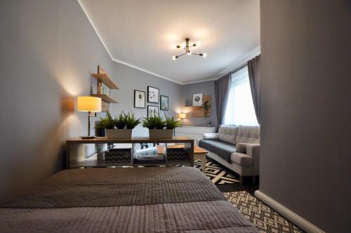 Abrahama Apartment في وارسو: غرفة معيشة مع سرير وأريكة