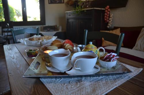 une table avec des tasses de thé et un plateau de nourriture dans l'établissement B&B Antica Botte Sassari, à Sassari