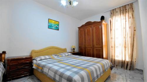 1 dormitorio con 1 cama y armario de madera en Apartment Glomazic, en Budva