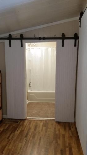 une chambre vide avec une porte s'ouvrant sur une baignoire dans l'établissement walker's retreat, à Durham Subdivision