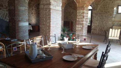 a wooden table with plates and wine glasses on it at Alloggi Agrituristici Antica Dimora in San Demetrio neʼ Vestini