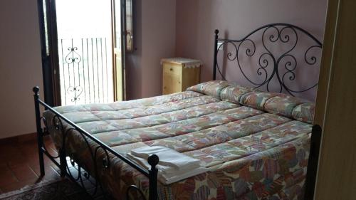 San Demetrio neʼ VestiniにあるAlloggi Agrituristici Antica Dimoraのベッドカバー付きのベッドルームのベッド1台