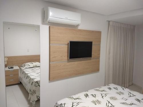 1 dormitorio con 1 cama y TV en la pared en Terrazzas 209, en João Pessoa