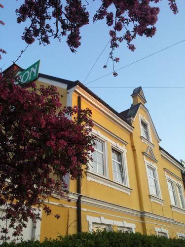 un edificio giallo con un cartello stradale davanti di Pension Elisabeth a Sankt Pölten