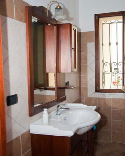 a bathroom with a sink and a mirror at Ambrosia casa vacanza " Giada " in Orosei
