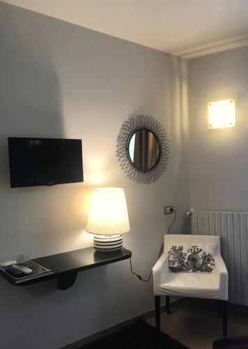 a room with a lamp and a chair and a mirror at Residenza Ca' degli Enzi in Verona