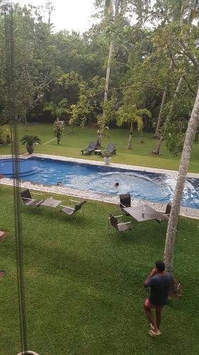 a man standing in front of a swimming pool at Good Karma Villa in Bentota