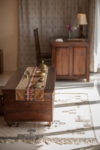 a living room with a wooden table and a chair at The Cape Goa in Cabo de Rama