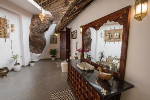 a bathroom with a large mirror and a sink at The Cape Goa in Cabo de Rama