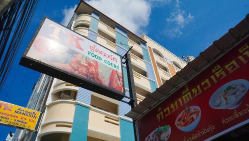 a tall building with signs on the side of it at TK mansion Hat Yai in Hat Yai