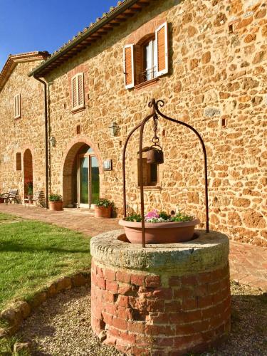 a stone building with a planter in front of it at Locanda Vesuna Hotel Countryhouse in Pienza