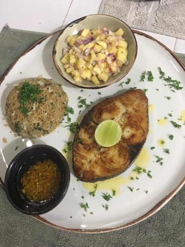 a plate of food with a piece of meat and vegetables at Good Karma Villa in Bentota