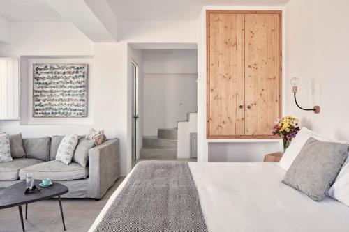 a living room with a bed and a couch at Elysian Santorini in Oia