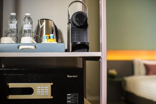a microwave sitting on a shelf next to a counter at Hotel Tranz in Bangkok