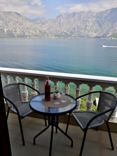 a table with two glasses of wine on a balcony at Apartments Popovic in Kotor