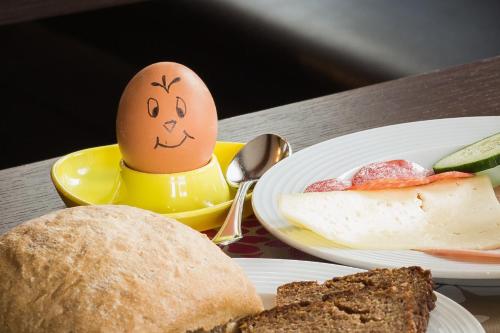 een ei met een gezicht erop getekend naast borden voedsel bij Saaletal Pension & Ferienwohnungen in Bad Bocklet