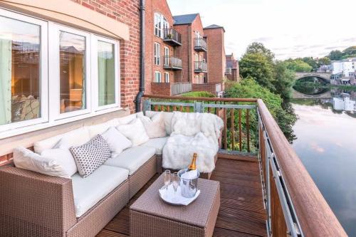 a white couch on a balcony with a view of the water at Riverside Retreat - Durham in Durham