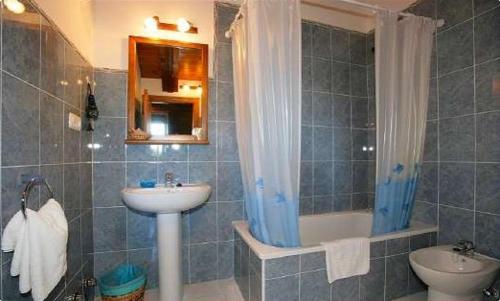 uma casa de banho com um lavatório, uma banheira e um WC. em Casa de Aldea El Frade em Camango
