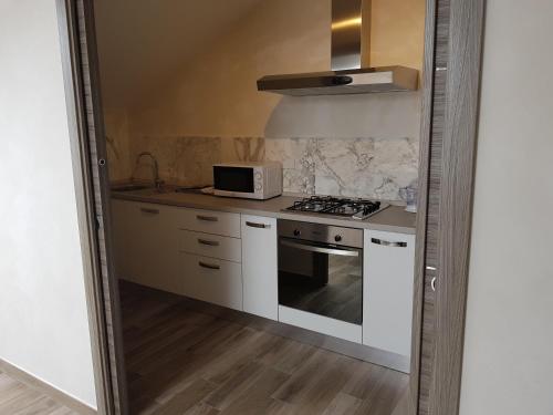 a kitchen with a stove and a microwave at memeapartments in Genova