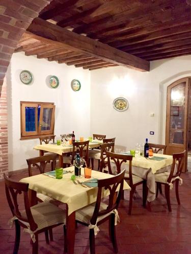 a dining room with tables and chairs and plates on the wall at Locanda Vesuna Hotel Countryhouse in Pienza