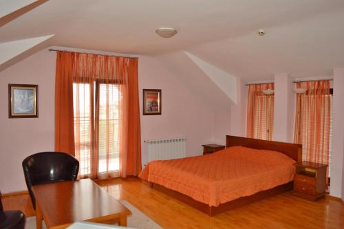 a bedroom with a bed with an orange bedspread at Hotel Drama Burgas in Burgas