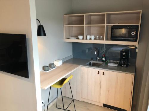 a small kitchen with a sink and a microwave at Skyline Airport Hotel in Vantaa