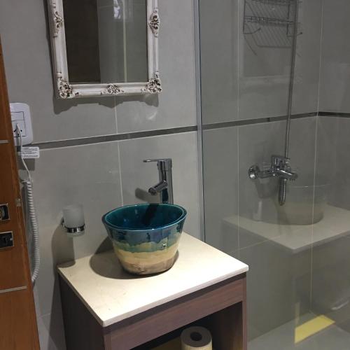 a bathroom with a blue bowl on a sink at Ivy in Resistencia