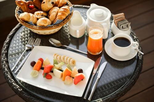 een tafel met een bord eten en een kopje koffie bij Amagi Aria Airport Transit Hotel in Negombo