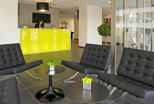 a lobby with two chairs and a table and a counter at Lagrange Aparthotel Lyon Lumière in Lyon