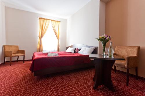 a bedroom with a bed and a table and a window at Pałac Pawłowice in Gorz