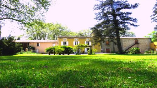 an old house with a grassy field in front of it at Château de la Prade in Bram