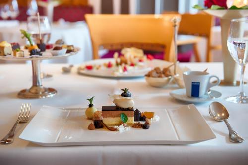 a table with a white plate with food on it at Hotel Landhaus Feckl in Böblingen