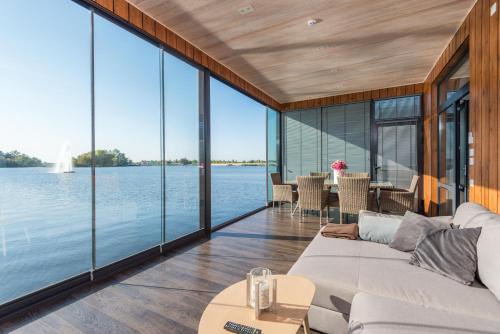 a living room with large windows and a view of the water at Riviera Zoloche Resort & Spa in Vishenki