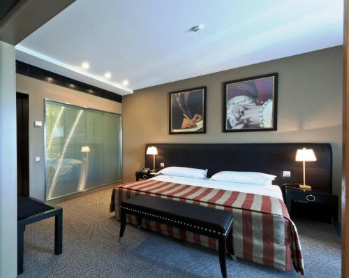a bedroom with a bed and two pictures on the wall at Hotel Casino Chaves in Chaves