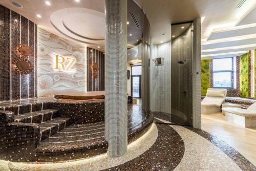 a lobby with a spiral staircase and a room with at Riviera Zoloche Resort & Spa in Vishenki