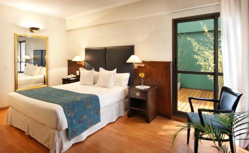 a hotel room with a bed and a chair at Hotel Dolmen in Buenos Aires