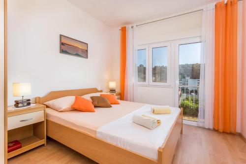 a bedroom with a bed and a large window at Apartmani LuNa in Hvar