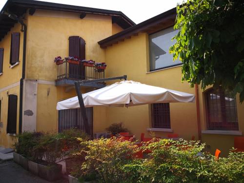 カスティリオーネ・デッレ・スティヴィエーレにあるLa Vecchia Tramviaの黄色の建物前の白傘