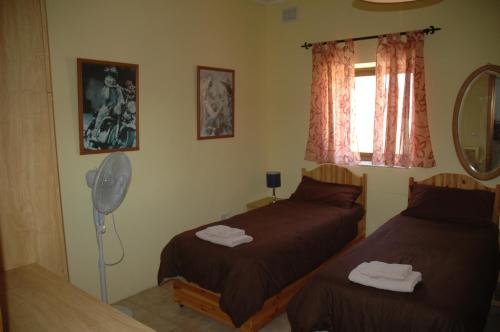 een slaapkamer met 2 bedden, een ventilator en een spiegel bij 31 Memories in Pembroke 