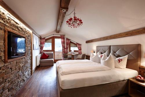 a bedroom with a large bed and a stone wall at Hotel Gasthof Perauer in Mayrhofen