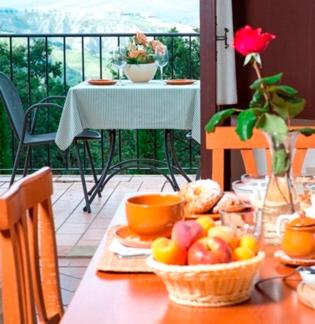 a table with a basket of fruit on a balcony at Agriturismo Selvella in Radicofani