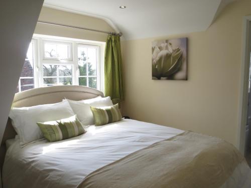Una cama con sábanas blancas y almohadas en un dormitorio en Oxford Apartments 2 en Oxford