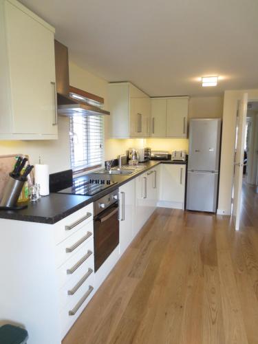 a kitchen with white cabinets and a wooden floor at Oxford Apartments 2 in Oxford