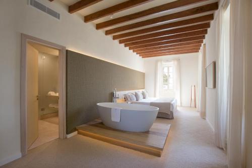 a bathroom with a large tub and a bed at Can Simoneta - Adults Only in Canyamel