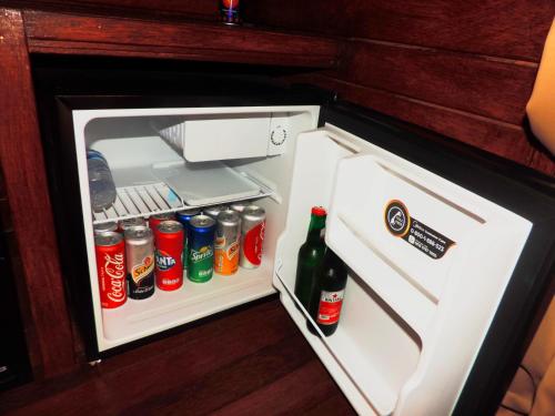 an open refrigerator with sodas and drinks in it at D'Coin Lembongan in Nusa Lembongan